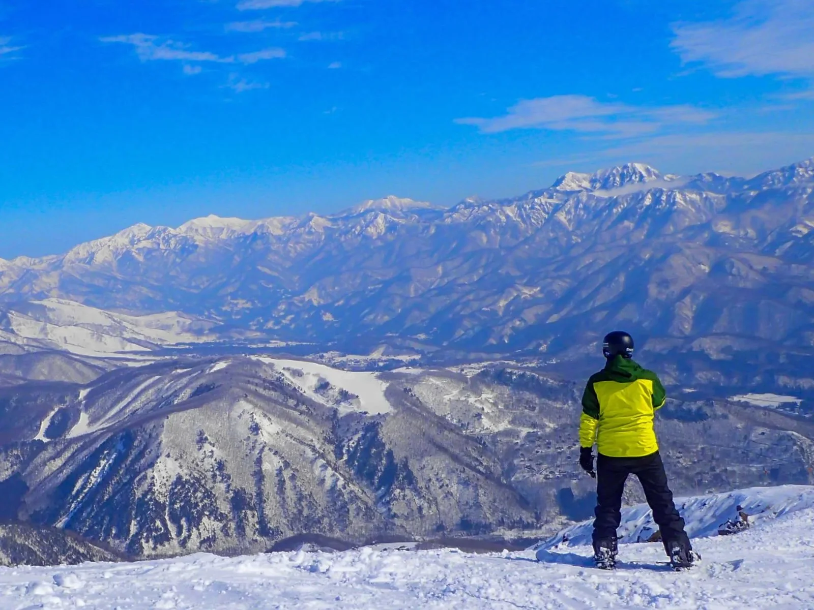 Snowboarder frente a los Alpes del Norte nevados en Hakuba