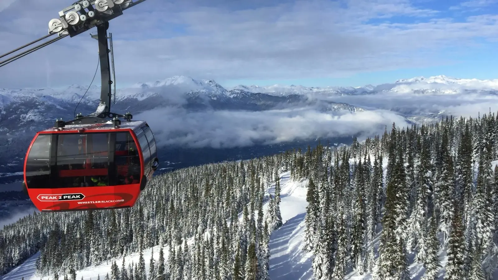 Red Peak 2 Peak gondola cabin above the snowy forests of Whistler Blackcomb